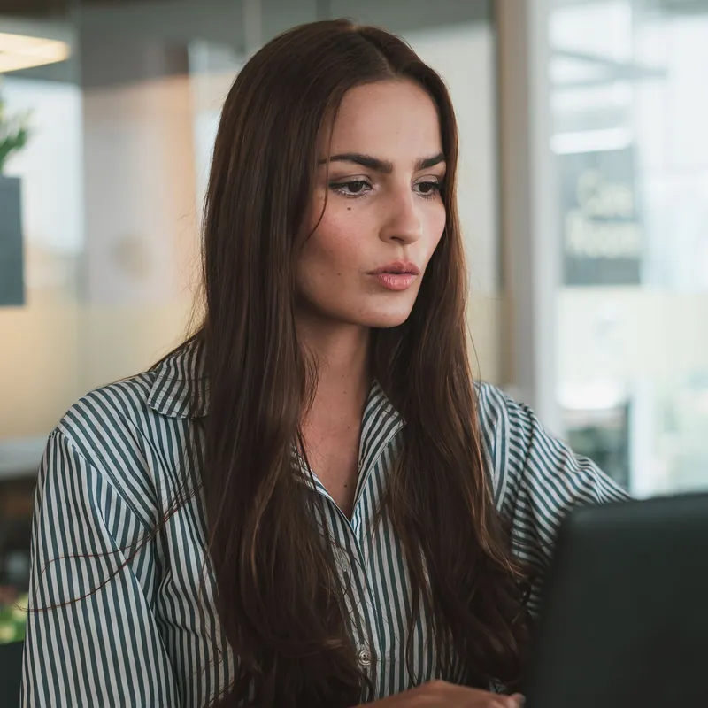 A professional working on a laptop in a bright office